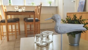 Un espace repas comprenant une table, des chaises et une sculpture d’oiseau décorative.