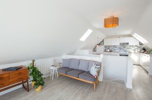 A modern loft apartment with a kitchen, dining area, and a cozy seating area.