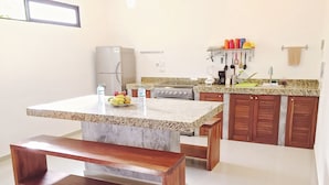 A kitchen with a granite countertop, wooden bench, and cabinets. - Nestled in the heart of Tulum town, steps away from Tulum's most lively street (Tulum)