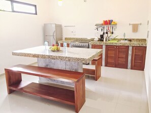 A kitchen with a granite countertop, wooden bench, and cabinets. - Nestled in the heart of Tulum town, steps away from Tulum's most lively street (Tulum)