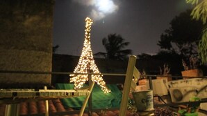 A model of the Eiffel Tower illuminated at night with a moon in the background. - Hostal La Antigua Capsula (Cali)