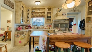 A kitchen with wooden cabinets, a farmhouse sign, and a large window. - BYRD'S FARMHOUSE CHICK-INN COOP (Shiner)