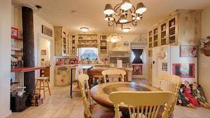 A traditional kitchen with wooden cabinets, a central island, and vintage decor. - BYRD'S FARMHOUSE CHICK-INN COOP (Shiner)