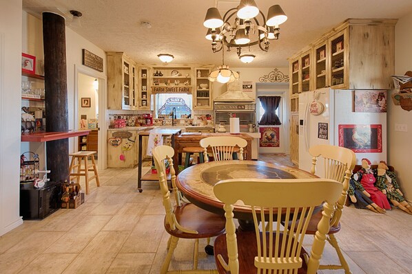 A traditional kitchen with wooden cabinets, a central island, and vintage decor. - BYRD'S FARMHOUSE CHICK-INN COOP (Shiner)