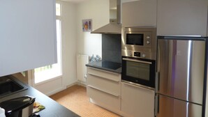 Eine moderne Küche mit Edelstahlgeräten, darunter eine Mikrowelle, ein Backofen und ein Kühlschrank.
