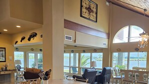 A spacious kitchen with a large island, a dining area with a view of the outdoors, and a high ceiling with wooden beams.