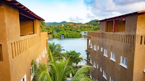 Ein Hotel mit Blick auf einen Fluss, Balkonen und einem Poolbereich.