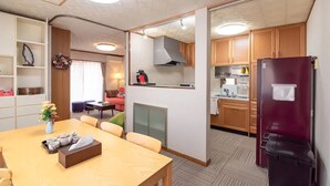 Una habitación de hotel compacta con comedor, kitchenette y sala de estar.