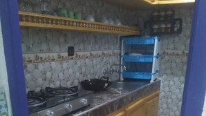 A compact kitchen with a gas stove, wooden cabinets, and a tiled backsplash. - Typical Riad at motivating price (Marrakech)