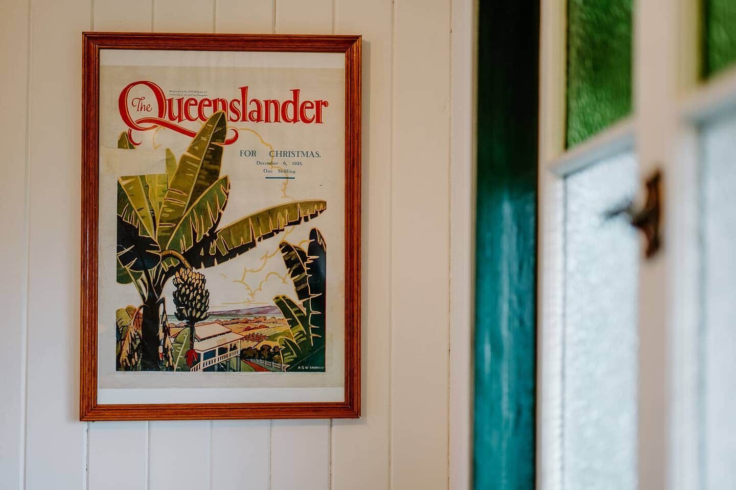 Un cartel de edición navideña de Queensland enmarcado en una pared.