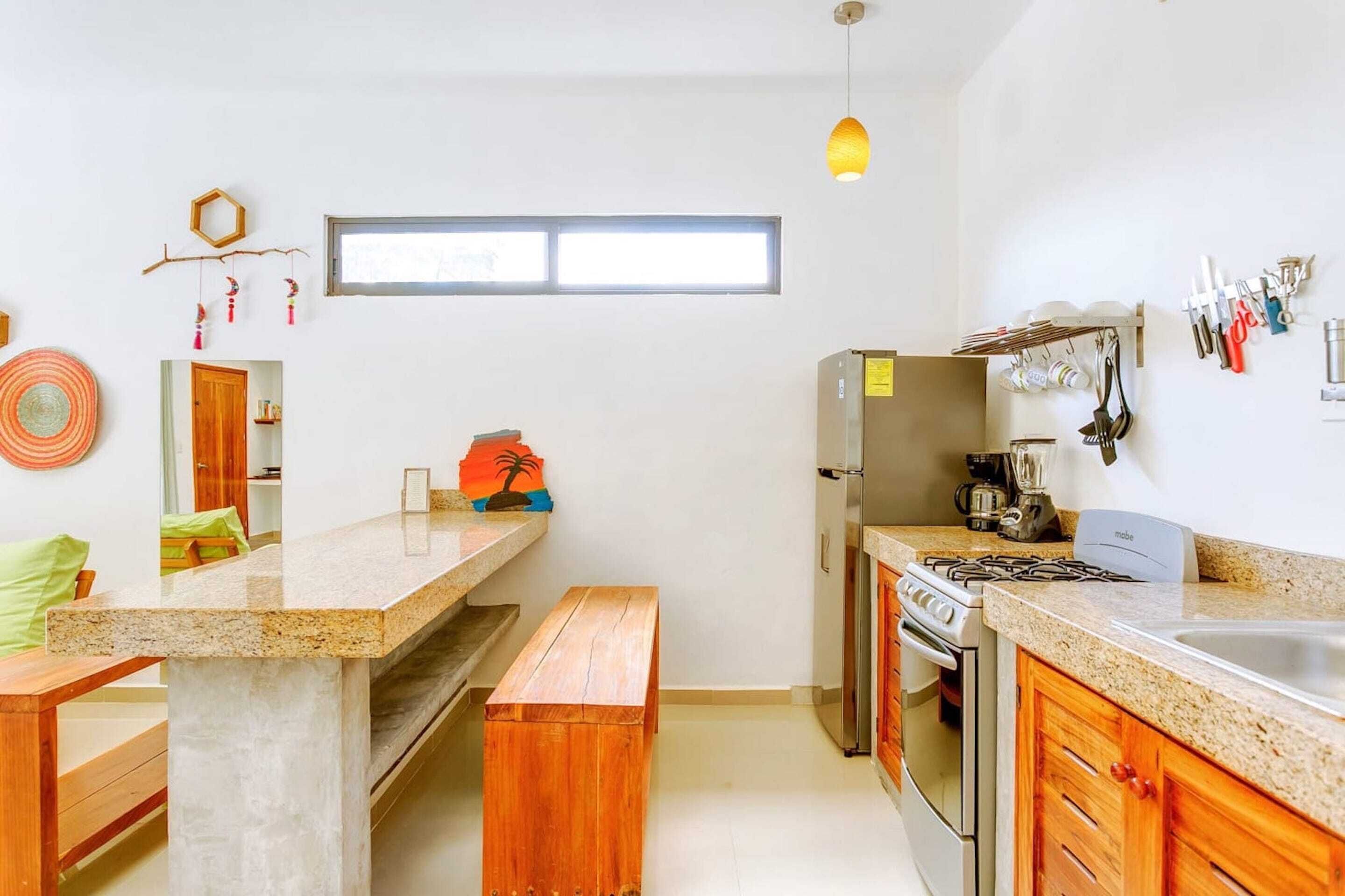 Una cucina moderna con piani di lavoro in granito, forno incassato e piano cottura a gas.