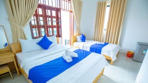 A hotel room with two beds, each with blue and white bedding, and a small refrigerator. - TiMee Hotel & Apartment (Nam Nha Trang)