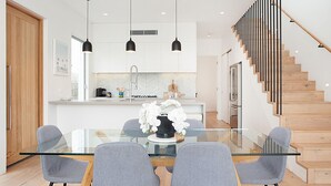 A modern kitchen with white cabinets, a central island, and pendant lighting.