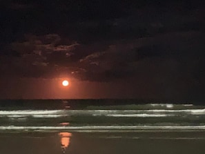 A beach scene with waves, a moon, and a cloudy sky. - PERUÍBE: House 500 meters from the beach - Recanto; Ruins of Abarebebê. (Peruíbe)