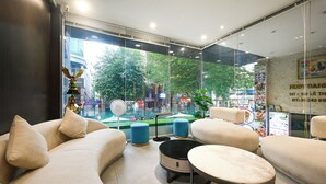 A modern hotel lobby with a seating area, large windows, and a view of the city. - Ruby Saigon Hotel - Ben Thanh (Ho Chi Minh City)