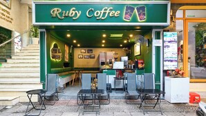 A Ruby Coffee shop with a green exterior, outdoor seating area, and a menu board visible inside. - Ruby Saigon Hotel - Ben Thanh (Ho Chi Minh City)