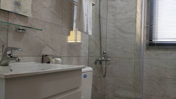 Un baño con inodoro, lavamanos y ducha.