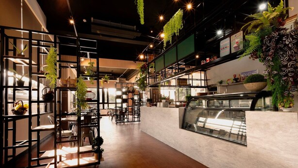 A modern interior with wooden flooring, black metal partitions, and hanging plants. - K-1 Hotel (Yuanlin)