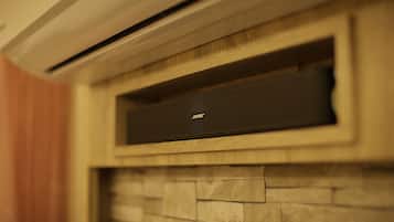A wall-mounted air conditioning unit with a wooden panel and stone-like texture below it.
