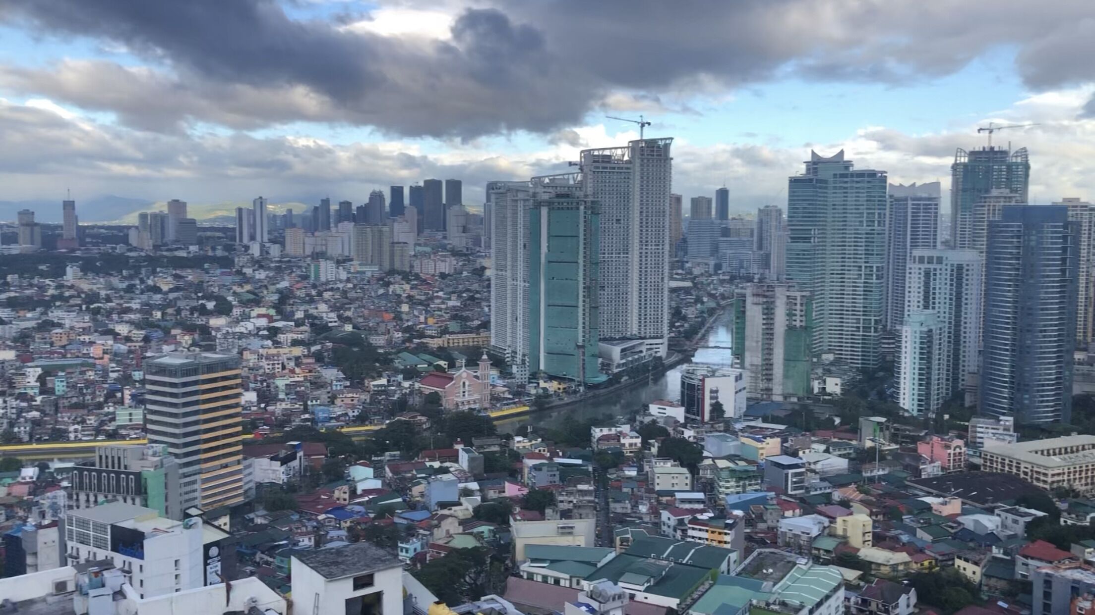 Un paisaje urbano con rascacielos, un río y una combinación de edificios residenciales y comerciales.