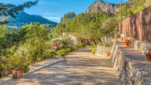A paved pathway leading to a building with stone walls and potted plants. - Beautiful Holiday Home Miravall with Mountain View (Puigpunyent)
