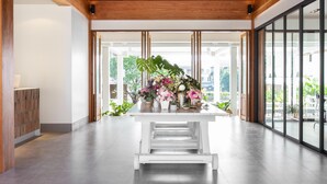 A modern interior with a central white table displaying various potted plants. - Sook Hotel (Ranong)