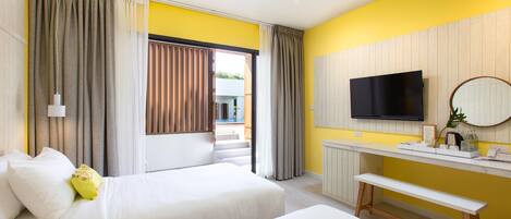 Habitación de hotel con dos camas, un escritorio, un televisor y un banco.