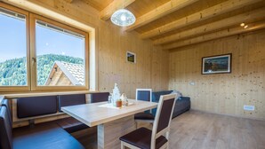 Un intérieur en bois comprenant une table à manger, des bancs et un canapé.