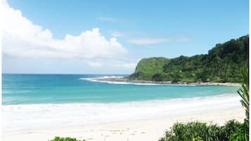 On the beach, white sand, beach towels, beach volleyball