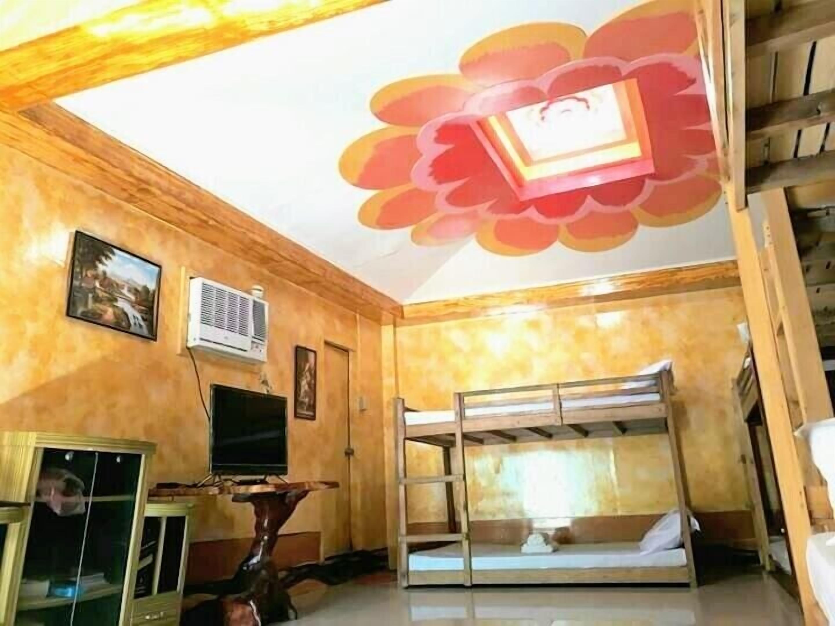 A room with bunk beds, a television, and a decorative ceiling.