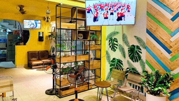 Un interior moderno con una estantería de madera, un televisor montado en la pared y un revestimiento mural con patrón de espiga.