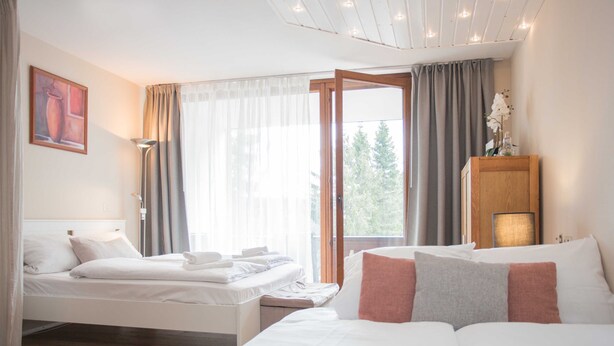 A hotel room with a bed, a bedside table, a lamp, a window with curtains, and a painting on the wall. - Apartment Bike & Ski Kappe at the bike park / ski lift - Apartment Bike & Ski Kappe (Winterberg)