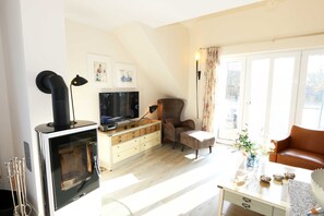 A living room with a fireplace, a television, a sofa, and a coffee table.