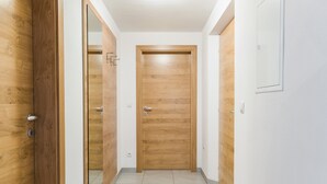 A hallway with wooden doors and a tiled floor. - Holiday Apartment "Hofschenke Pfeiftal Almenrausch" with Terrace, Garden & Wi-Fi (St. Martin in Passeier)
