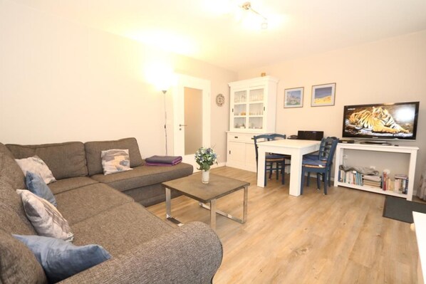 A living room with a sofa, coffee table, and a television.