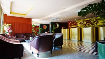 A lobby with leather armchairs, a reception desk, and a checkered floor.