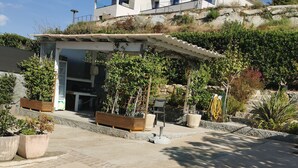 A modern house with a covered patio area, outdoor seating, and potted plants. - Semi-detached Villa Sea View - Private Parking - Near Town Center and Beaches (Propriano)