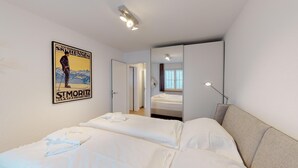 Una habitación de hotel con una cama, un espejo, una lámpara de escritorio y un cartel en la pared.