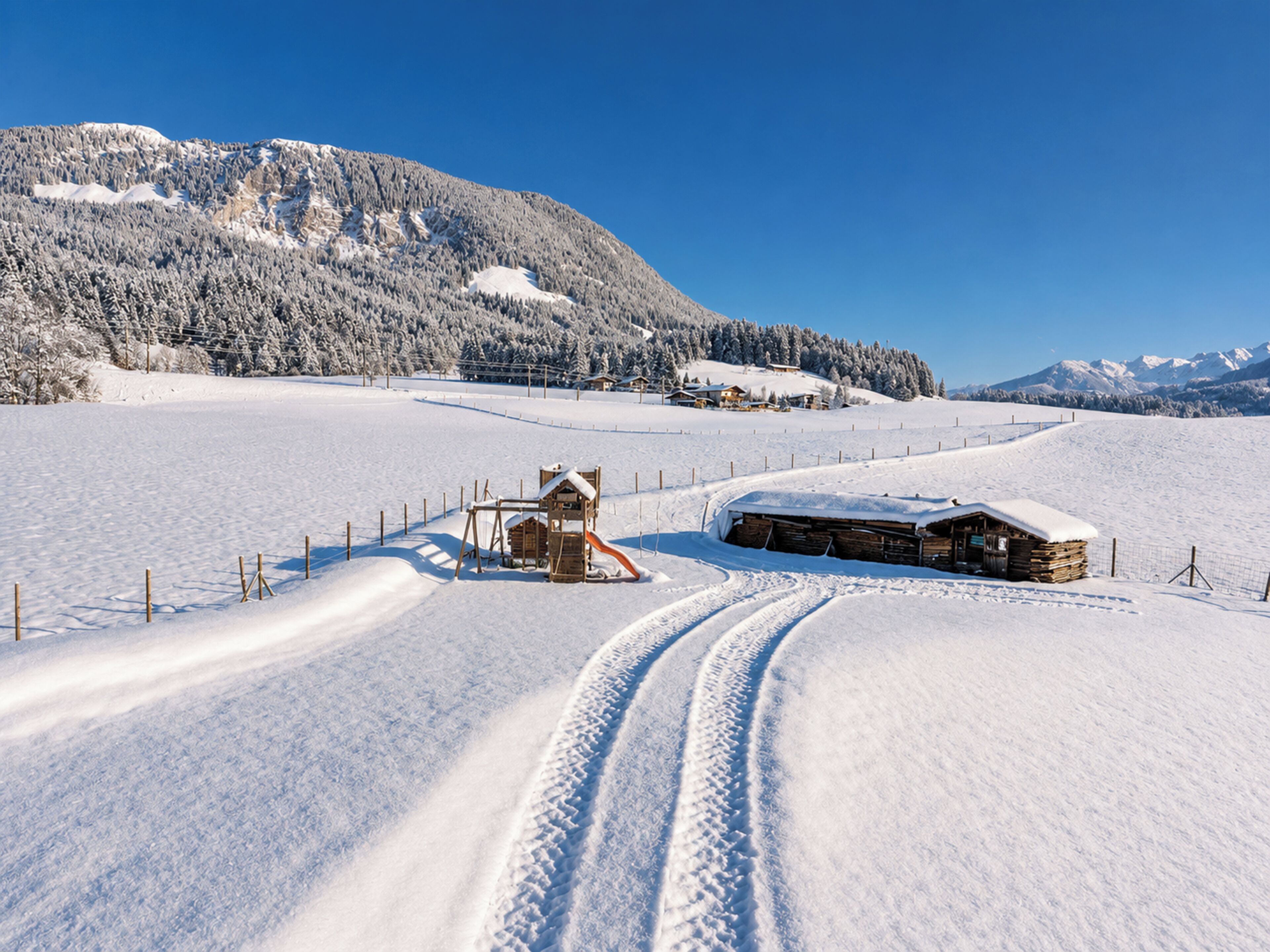 Un paysage enneigé avec une cabane en bois et une structure de jeux.