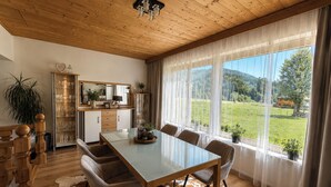A spacious dining area with a long table, chairs, and a cowhide rug. - Apartment Katarina (Fieberbrunn)