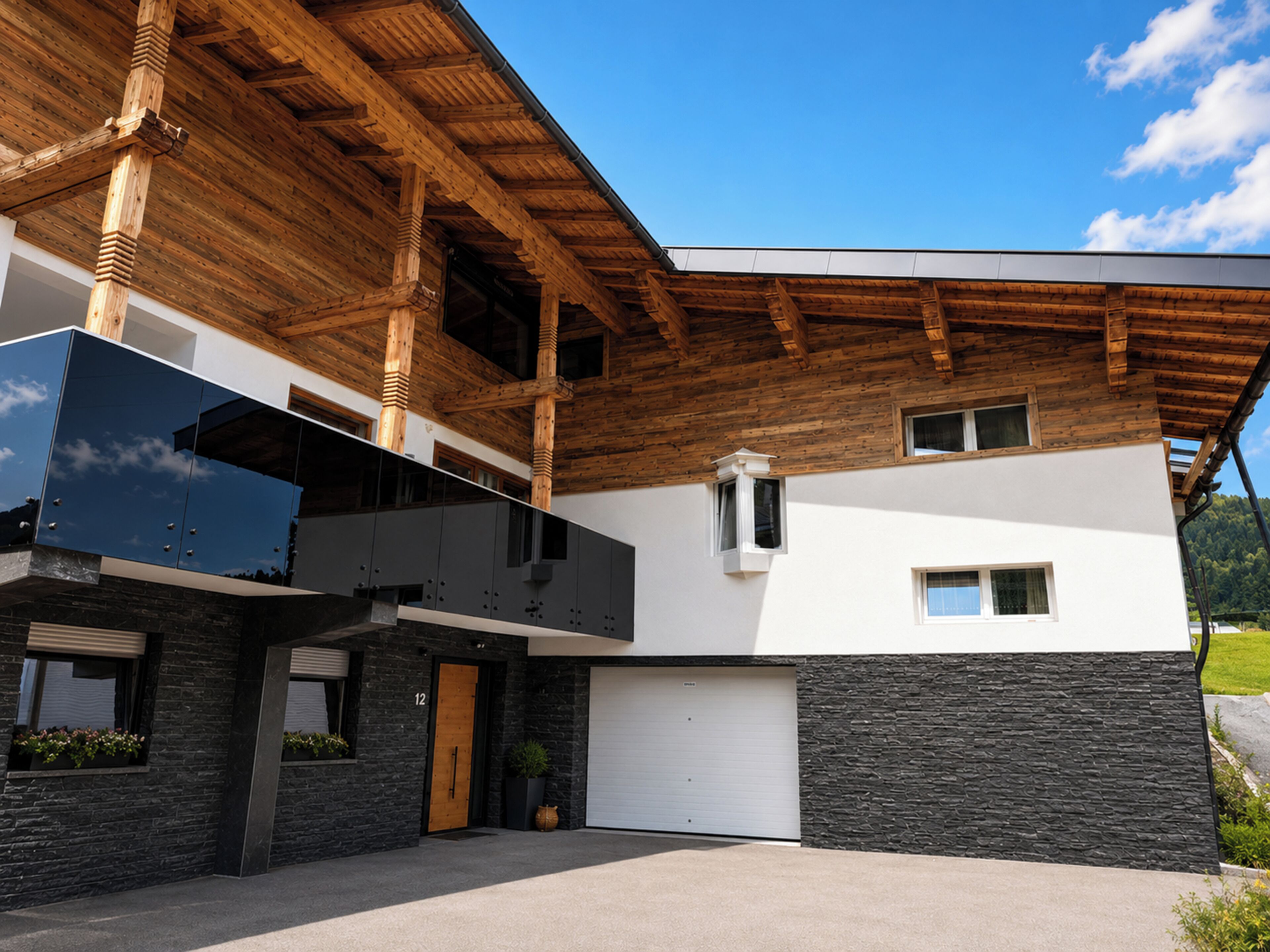 Ein modernes Gebäude mit Holzdach, Garage und einer Fassade aus Stein.