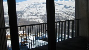 Ein Balkon mit Blick auf ein verschneites Gebirge.