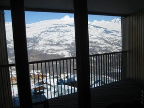 A balcony with a view of a snow-covered mountain range.