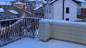 A snowy residential area with a white building and a church tower. - Cerdanya Family House (Font Romeu - Odeillo)