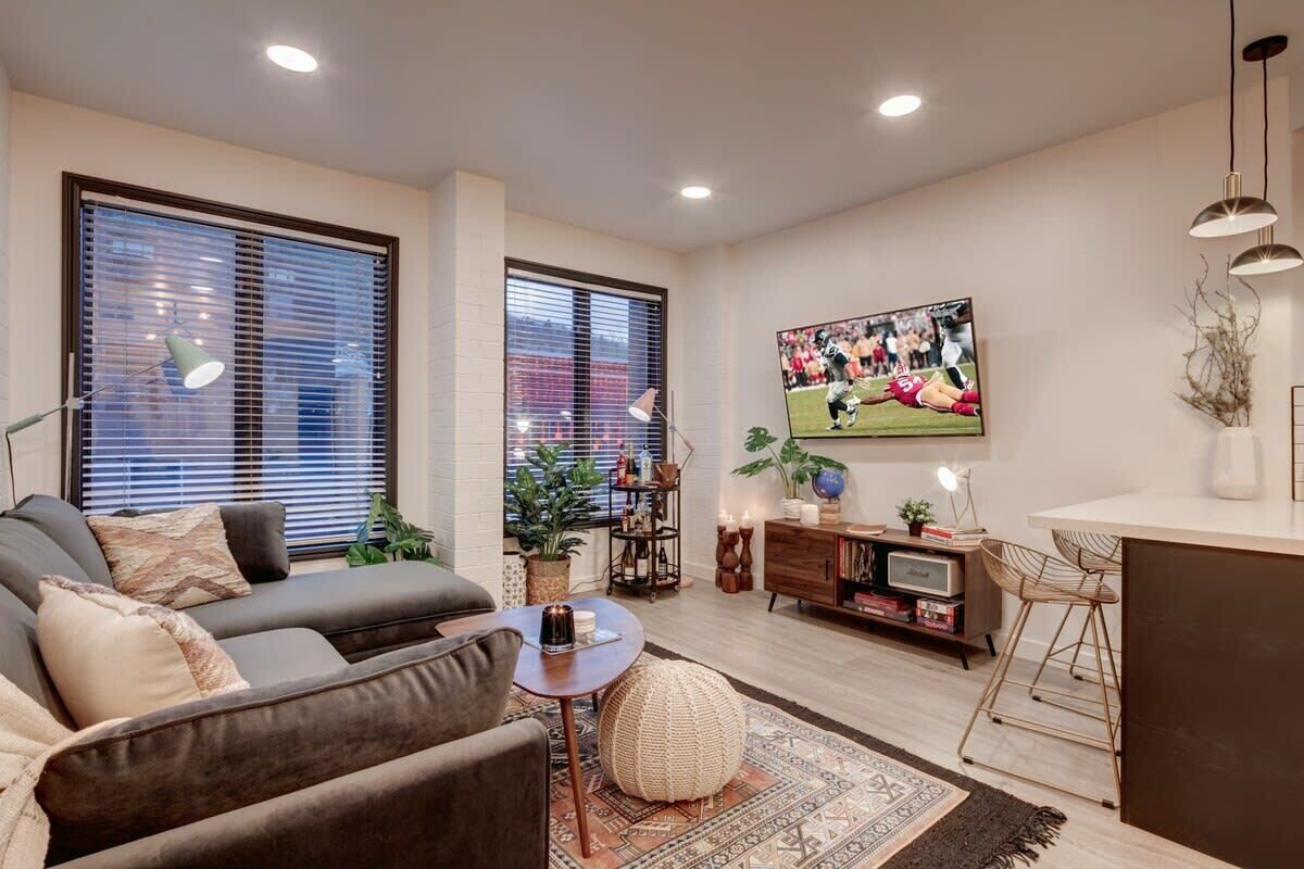 Un salon moderne avec un canapé, une table basse et un téléviseur fixé au mur.
