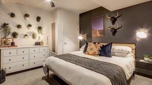 A bedroom with a bed, a ceiling fan, wall-mounted plants, and decorative skulls. - The Sanctuary on Main Modern 1BR Walk to Town Lift (Park City)