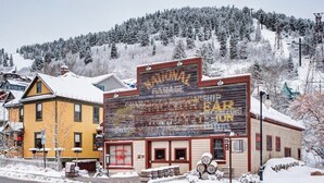 A building with a large sign reading "NATIONAL GARAGE" and "EARTH RUN." - The Sanctuary on Main Modern 1BR Walk to Town Lift (Park City)