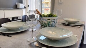 A dining table set with plates, bowls, wine glasses, and a bowl of salad.