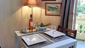 A dining table set with plates, a wine glass, a bottle, and a candle holder. - N&J -  ANGEL'S BAY - Central - Close sea (Niza)