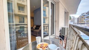 A balcony with a glass table, a plate of pastries, and a white mug. - N&J - RIVIERA PROVENCE - CENTRAL - NEAR SEA (Niza)